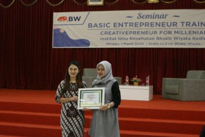 Penyerahan cinderamata kepada narasumber Ibu Dewi Kartika Sari, SSY.,M.Gizi