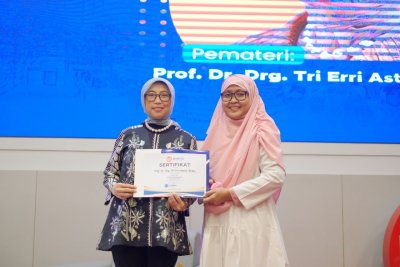 jelas Prof. Dr. drg. Tri Erri Astoeti., M. Kes. menerima cinderamata dari Dekan FKG IIK Bhakta drg. Afrida Nurmalasari., M.Kes